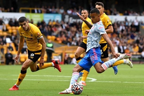 Mason Greenwood of Manchester United battles for possession with Conor Coady of Wolverhampton Wanderers during the Premier League match between...