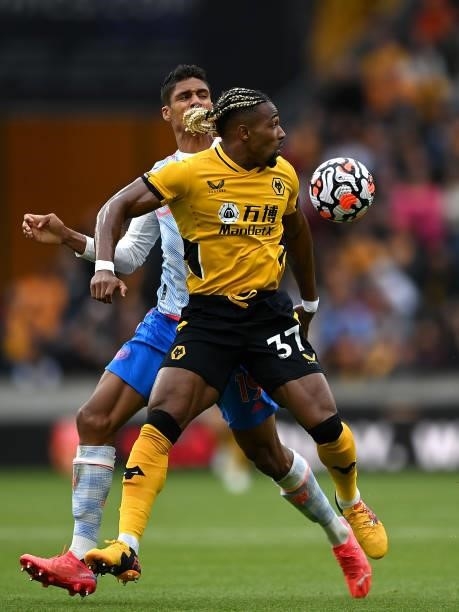Adama Traore of Wolverhampton Wanderers battles for possession with Raphaël Varane of Manchester United during the Premier League match between...