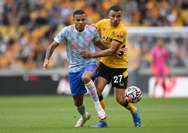 Mason Greenwood of Manchester United battles for possession with Romain Saiss of Wolverhampton Wanderers during the Premier League match between...