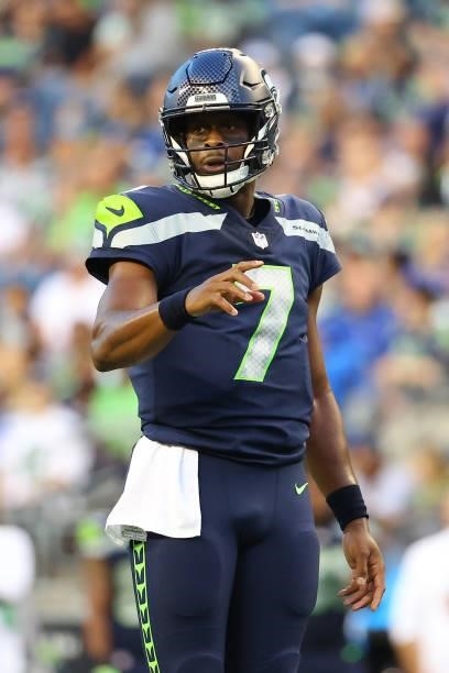Geno Smith of the Seattle Seahawks reacts the ball against the Los Angeles Chargers in the first quarter during the NFL preseason game at Lumen Field...