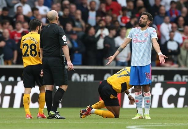 Bruno Fernandes of Manchester United speaks to Referee Mike Dean during the Premier League match between Wolverhampton Wanderers and Manchester...