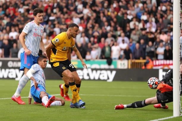 Romain Saiss of Wolverhampton Wanderers has a shot saved by David De Gea of Manchester United during the Premier League match between Wolverhampton...