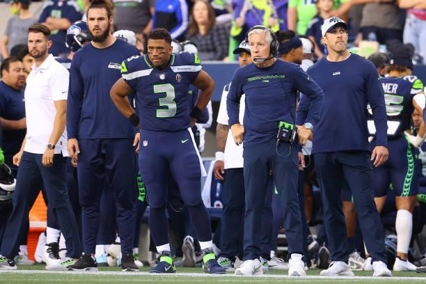 Russell Wilson and head coach Pete Carroll of the Seattle Seahawks look on during the NFL preseason game against the Los Angeles Chargers at Lumen...