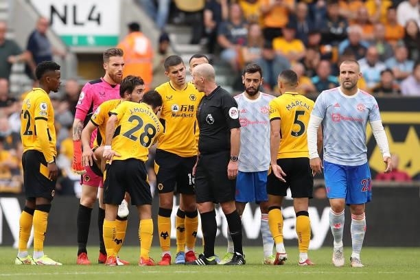 Players of Wolverhampton Wanderers surround Match Referee Mike Dean during the Premier League match between Wolverhampton Wanderers and Manchester...