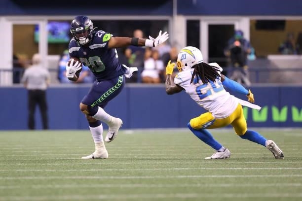 Rashaad Penny of the Seattle Seahawks carries the ball against Tevaughn Campbell of the Los Angeles Chargers in the second qarte during the NFL...
