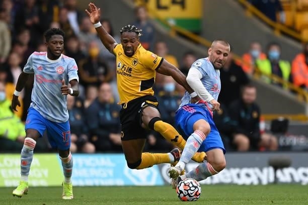 Adama Traore of Wolverhampton Wanderers is tackled by Luke Shaw of Manchester United during the Premier League match between Wolverhampton Wanderers...