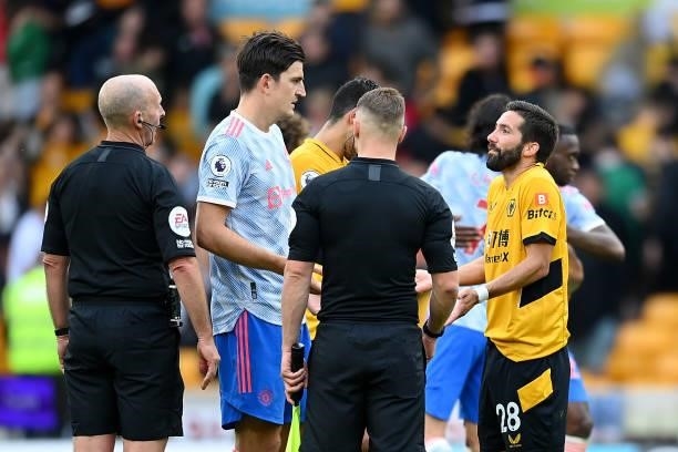 Match Referee Mike Dean interacts with Joao Moutinho of Wolverhampton Wanderers following the Premier League match between Wolverhampton Wanderers...