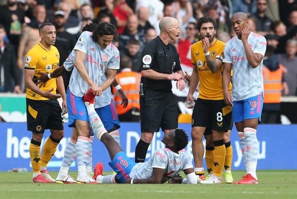 Edinson Cavani of Manchester United helps Paul Pogba with cramp during the Premier League match between Wolverhampton Wanderers and Manchester United...