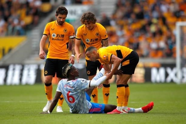 Paul Pogba of Manchester United is helped to his feet by Marcal of Wolverhampton Wanderers during the Premier League match between Wolverhampton...