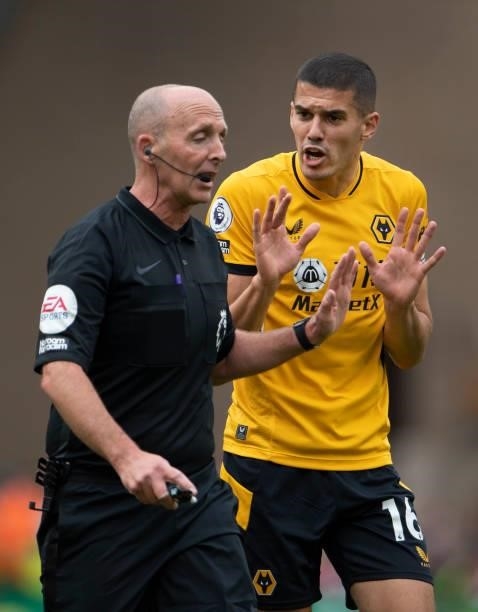 Conor Coady of Wolverhampton Wanderers argues with referee Mike Dean during the Premier League match between Wolverhampton Wanderers and Manchester...