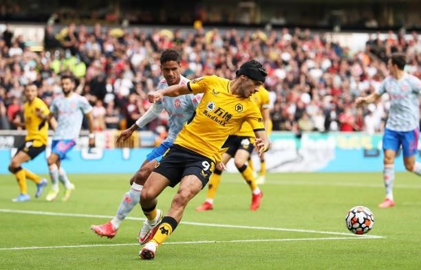 Raul Jimenez of Wolverhampton Wanderers controls the ball under pressure from Raphael Varane of Manchester United during the Premier League match...
