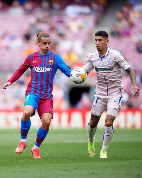Antoine Griezmann of FC Barcelona competes for the ball with Mathias Olivera of Getafe CF during the La Liga Santander match between FC Barcelona and...