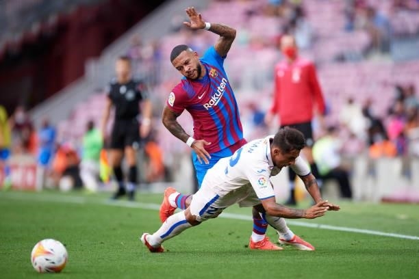 Memphis Depay of FC Barcelona clashes with Damian Suarez of Getafe CF during the La Liga Santander match between FC Barcelona and Getafe CF at Camp...