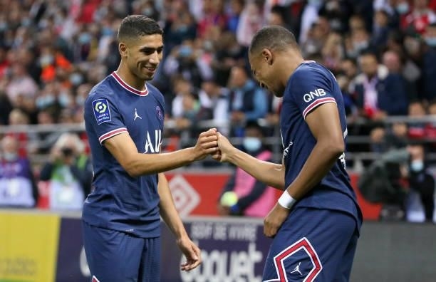 Kylian Mbappe of PSG celebrates his first goal with Achraf Hakimi during the Ligue 1 Uber Eats match between Stade Reims and Paris Saint Germain at...