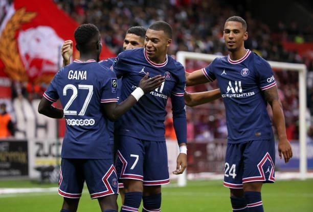 Kylian Mbappe of PSG celebrates his second goal with Thilo Kehrer and teammates during the Ligue 1 Uber Eats match between Stade Reims and Paris...