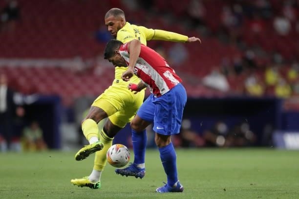 Luis Suarez of Atletico de Madrid competes for the ball with Etienne Capoue of Villarreal CF during the La Liga Santader match between Club Atletico...