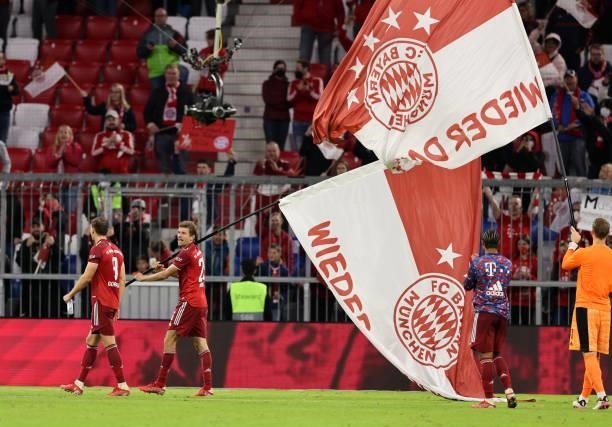 Thomas Mueller of Bayern Muenchen waves a flag as a sign of appreciation following the Bundesliga match between FC Bayern München and Hertha BSC at...