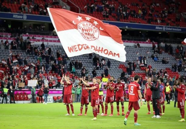 Joshua Kimmich of Bayern Muenchen waves a flag as a sign of appreciation following during the Bundesliga match between FC Bayern München and Hertha...