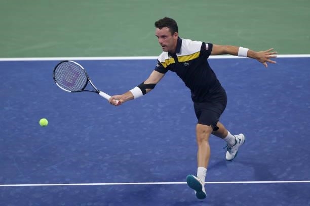 Roberto Bautista Agut of Spain returns the ball against Nick Kyrgios of Australia during their Men's Singles first round match on Day One of the 2021...