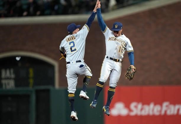 Luis Urias and Kolten Wong of the Milwaukee Brewers celebrates defeating the San Francisco Giants 3-1 at Oracle Park on August 30, 2021 in San...