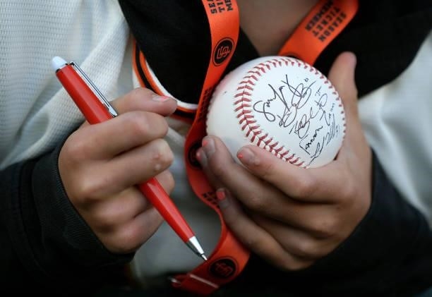 Detailed view of a fan holding an autograph baseball prior to the start of an Major League Baseball game between the Milwaukee Brewers and San...