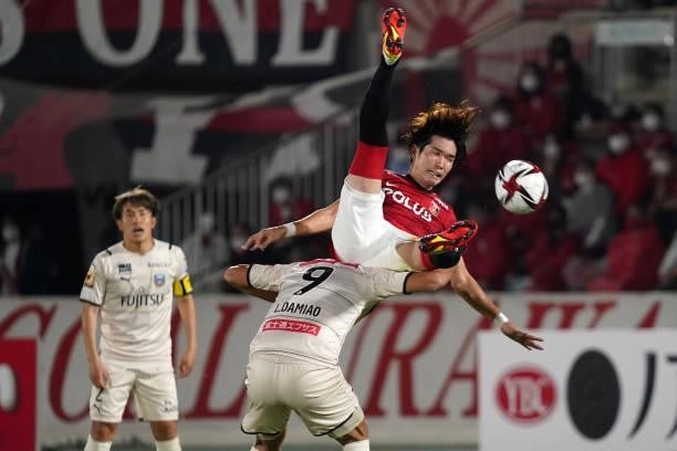 Takuya Iwanami of Urawa Red Diamonds and Leandro Damiao of Kawasaki Frontale compete for the ball during the J.League YBC Levain Cup quarter final...