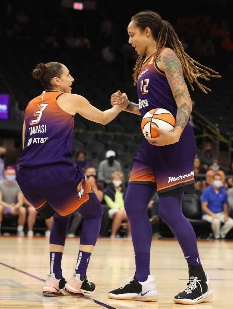 Brittney Griner of the Phoenix Mercury helps Diana Taurasi up from the court during the first half of the WNBA game at the Footprint Center on August...