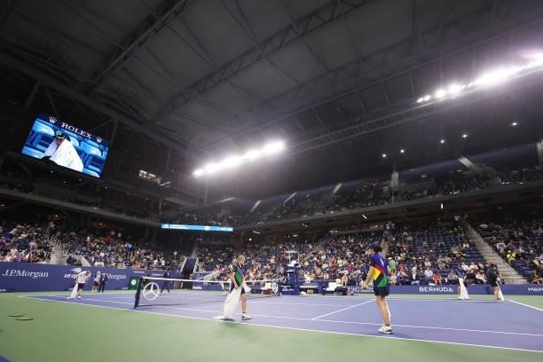 Crew members dry the court after rain enters through the outer openings of the roof causing a delay during the match between Kevin Anderson of South...