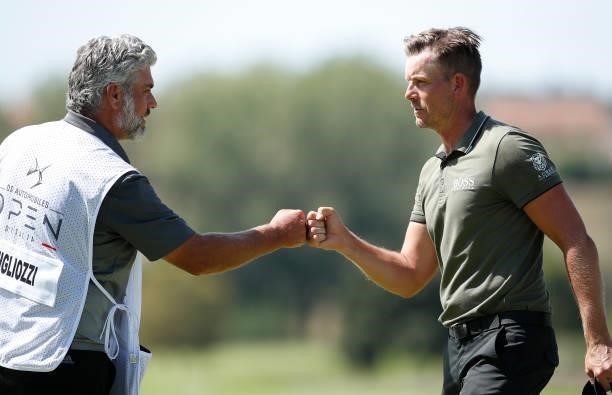 Henrik Stenson of Sweden bumps fists with Guido Migliozzi 's caddie on the ninth hole during Day One of The Italian Open at Marco Simone Golf Club on...