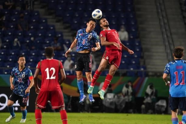 Wataru Endo of Japan and Khalid Khalifa Al Hajri of Oman compete for the ball during FIFA World Cup Asian Qualifier Final Round Group B match between...