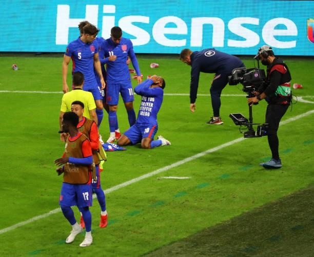 Raheem Sterling celebrates with his team-mates after opening the scoring for England while cups are thrown at them by Hungary supporters during the...