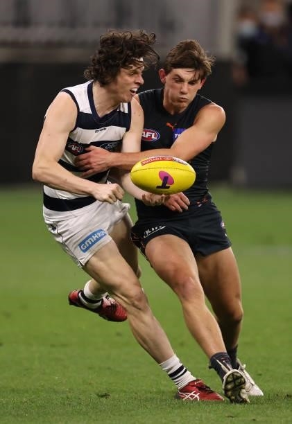 Max Holmes of the Cats handballs whilst being tackled by Conor Stone of the Giants during the AFL First Elimination Final match between Geelong Cats...