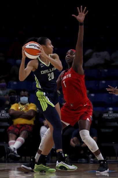 Forward Isabelle Harrison of the Dallas Wings passes the ball against guard Odyssey Sims of the Atlanta Dream and forward Elizabeth Williams of the...