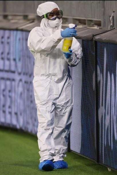 Cleaning staff wearing PPE sanitize contact surfaces following the AFL First Elimination Final match between the Geelong Cats and Greater Western...