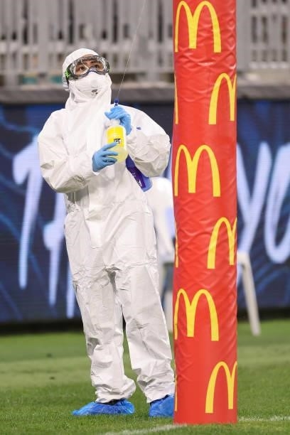 Cleaning staff wearing PPE sanitize the goal pads following the AFL First Elimination Final match between the Geelong Cats and Greater Western Sydney...