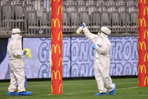 Cleaning staff wearing PPE sanitize the goal pads following the AFL First Elimination Final match between the Geelong Cats and Greater Western Sydney...