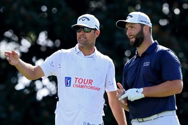 Jon Rahm of Spain and his caddie line up a shot from the 14th tee during the second round of the TOUR Championship at East Lake Golf Club on...