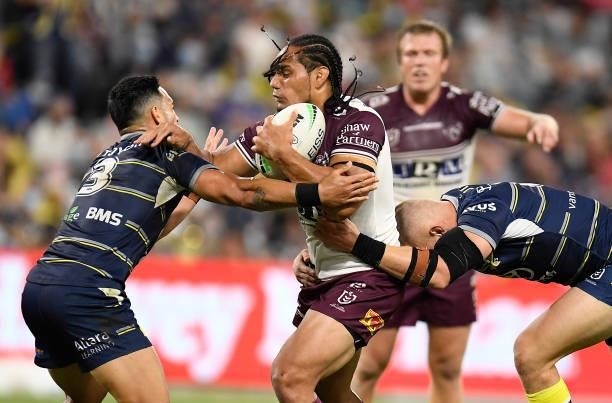 Martin Taupau of the Sea Eagles is tackled by Valentine Holmes and Coen Hess of the Cowboys during the round 25 NRL match between the North...