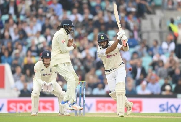 Cheteshwar Pujara of India hits a four past Haseeb Hameed of England during the third day of the 4th LV= Test Match between England and India at The...