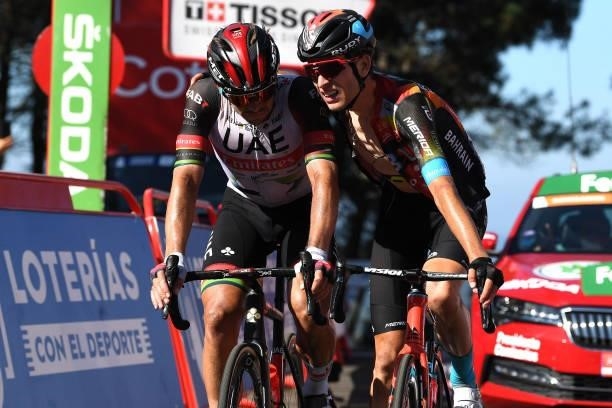 Ryan Gibbons of South Africa and UAE Team Emirates and Gino Mäder of Switzerland and Team Bahrain Victorious react after cross the finishing line...