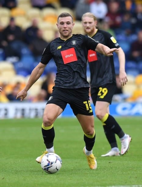 Jack Muldoon of Harrogate Town runs with the ball during the Sky Bet League Two match between Mansfield Town and Harrogate Town at One Call Stadium...