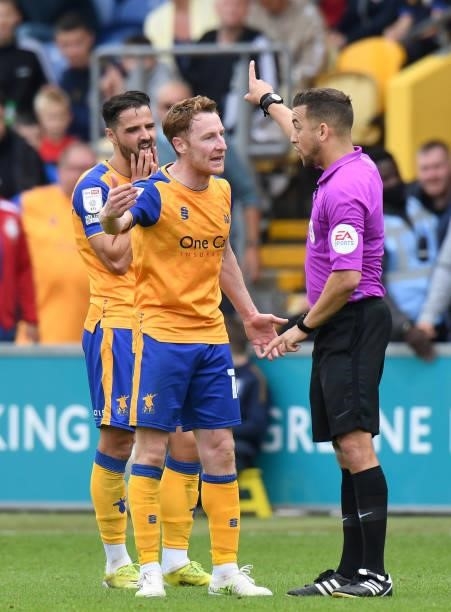 Referee Paul Howard talks to Stephen Quinn of Mansfield Town during the Sky Bet League Two match between Mansfield Town and Harrogate Town at One...