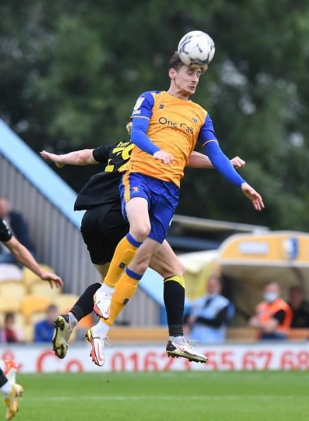 Elliott Hewitt of Mansfield Town is challenged in the air by Luke Armstrong of Harrogate Town during the Sky Bet League Two match between Mansfield...