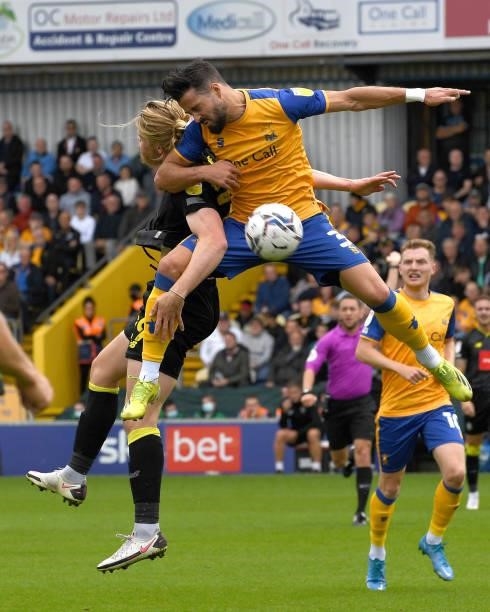 Stephen McLaughlin of Mansfield Town is challenged by Luke Armstrong of Harrogate Town during the Sky Bet League Two match between Mansfield Town and...