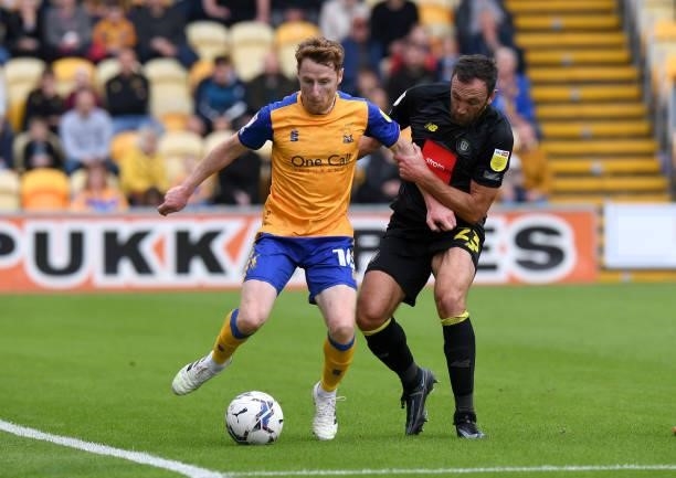 Stephen Quinn of Mansfield Town is challenged by Rory McArdle of Harrogate Town during the Sky Bet League Two match between Mansfield Town and...