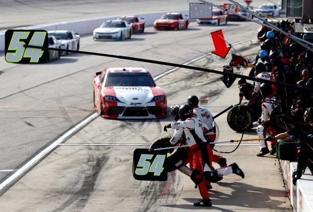 The pit crew of the SportClips Haircuts Toyota, driven by Denny Hamlin leap into action during the NASCAR Xfinity Series Sport Clips Haircuts VFW...