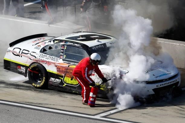 Member of the NASCAR Safety Crew puts out a fire on the QPS Employment Group Chevrolet, driven by on pit road during the NASCAR Xfinity Series Sport...