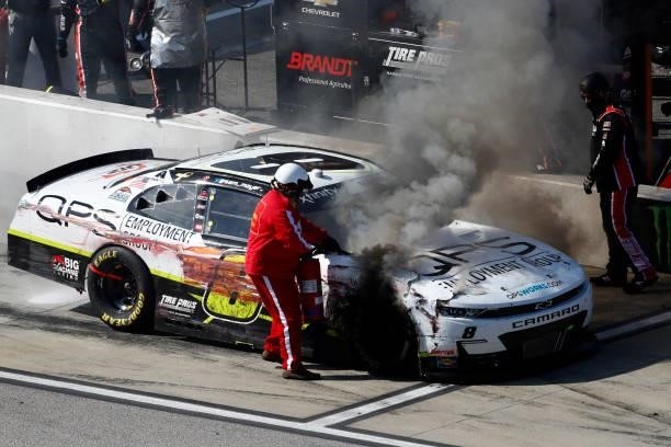 Member of the NASCAR Safety Crew puts out a fire on the QPS Employment Group Chevrolet, driven by on pit road during the NASCAR Xfinity Series Sport...