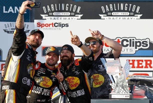 Noah Gragson, driver of the Bass Pro Shops/TrueTimber/BRCC Chevrolet, and crew members take a selfie in the Ruoff Mortgage victory lane after winning...