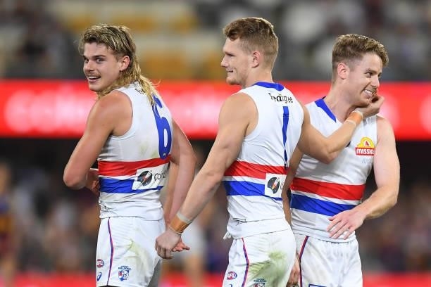 Western Bulldogs players Bailey Smith, Lachie Hunter and Adam Treloar celebrate victory during the AFL 1st Semi Final match between the Brisbane...